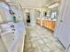 Bright bathroom with a soaking tub, tiled floors, and dual vanities at 10500 Horseshoe Falls Ct, Las Vegas, NV 89144