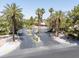 Gated community entrance with mature palm trees, professional landscaping and black asphalt entry in a desert climate at 110 Eagleview Ct, Henderson, NV 89074