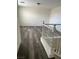 Landing featuring gray wood-look floors and white stair railing with a ceiling light at 11173 Hickory Glen St, Las Vegas, NV 89179