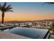 Striking aerial view of modern homes surrounded by mountains and desert landscape with a sparkling infinity pool at 12 Desert Lake Ln, Henderson, NV 89011