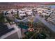 Aerial view of a modern community with homes featuring rooftop decks, pools, and lake views at 12 Desert Lake Ln, Henderson, NV 89011