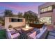 Contemporary backyard with a fire pit, TV, built-in seating, hot tub, and manicured lawn at 12 Desert Lake Ln, Henderson, NV 89011