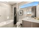 Modern bathroom featuring a shower-tub combo, gray tile, floating vanity, and natural light at 12 Desert Lake Ln, Henderson, NV 89011