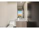 Powder room featuring a modern sink, mirror, toilet, and beautiful desert view through the window at 12 Desert Lake Ln, Henderson, NV 89011