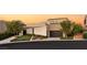 Contemporary home featuring unique architecture, a dark gray garage door, desert landscaping and gravel beds at 12 Desert Lake Ln, Henderson, NV 89011
