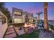 Modern outdoor space featuring a hot tub, fire pit, patio seating, and spiral staircase at 12 Desert Lake Ln, Henderson, NV 89011
