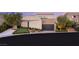 Modern home with a dark garage door, neutral stucco exterior, and desert landscaping on a quiet street at 12 Desert Lake Ln, Henderson, NV 89011