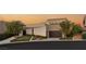 Stunning exterior shot featuring a modern home with mature landscaping, neutral colors, and a two-car garage at 12 Desert Lake Ln, Henderson, NV 89011