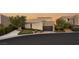 Modern home featuring clean lines, a two-car garage, and desert landscaping at sunset at 12 Desert Lake Ln, Henderson, NV 89011