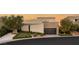 Contemporary home featuring clean lines, neutral tones, a dark garage door, and meticulously designed desert landscaping at 12 Desert Lake Ln, Henderson, NV 89011