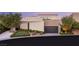 Modern home featuring contemporary architecture, desert landscaping, and a sleek garage at 12 Desert Lake Ln, Henderson, NV 89011