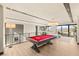 Spacious game room with a pool table, modern lighting, and views of the lake and surrounding mountains at 12 Desert Lake Ln, Henderson, NV 89011