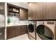 Well-organized laundry room with modern washer, dryer, storage cabinets and sink at 12 Desert Lake Ln, Henderson, NV 89011