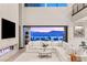 Bright, modern living room featuring a fireplace, large white couch, and expansive mountain views at 12 Desert Lake Ln, Henderson, NV 89011