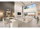 Spacious living room with a modern fireplace, high ceilings, and floor-to-ceiling windows with mountain views at 12 Desert Lake Ln, Henderson, NV 89011