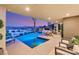 Stunning outdoor pool and patio with modern lounge chairs, dining, and spiral staircase overlooking cityscape at 12 Desert Lake Ln, Henderson, NV 89011