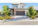 Two-story home with a stone accent column and brick driveway that leads to a dark brown garage door at 12039 Rockview Point St, Las Vegas, NV 89138