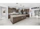 Spacious kitchen featuring a large island, modern appliances, dark wood cabinetry, and designer lighting fixtures at 12039 Rockview Point St, Las Vegas, NV 89138