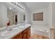 Bright bathroom with a double sink vanity, large mirror and separate tub and shower area at 1290 Dalene Ave, Henderson, NV 89002