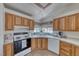 Well-lit kitchen featuring wood cabinets, white appliances, and a large sink with a window view at 1290 Dalene Ave, Henderson, NV 89002