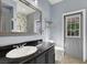 Cozy bathroom featuring a dark vanity, a decorative mirror, and stylish gray paint at 1306 Big Tree Ave, North Las Vegas, NV 89031