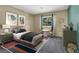 Stylish bedroom with a comfortable bed, playful artwork, and a bright window view at 1306 Big Tree Ave, North Las Vegas, NV 89031