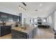 Open-concept kitchen with a large island, dark cabinetry, modern pendant lighting, and views to the living area at 1306 Big Tree Ave, North Las Vegas, NV 89031