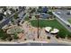 Aerial view of a community park featuring a playground, splash pad, basketball court, and walking paths at 1346 Crystal Hill Ln # 3, Henderson, NV 89012