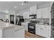 Well-lit kitchen features white cabinets, black appliances, and modern countertops at 1346 Crystal Hill Ln # 3, Henderson, NV 89012