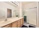 Bathroom featuring a double sink vanity, large mirror, and glass-enclosed shower at 1816 Eagle Mesa Ave, Henderson, NV 89012