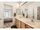 Bathroom featuring a double sink vanity, large mirror, and open bedroom views at 1816 Eagle Mesa Ave, Henderson, NV 89012