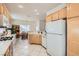 Spacious kitchen area featuring light wood cabinets and white appliances at 1816 Eagle Mesa Ave, Henderson, NV 89012