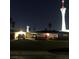 Exterior view of a well-lit home with a red door, set against the backdrop of the Stratosphere at night at 2217 Santa Ynez Dr, Las Vegas, NV 89104