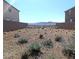 Low-maintenance backyard showcasing desert landscaping and a wrought-iron fence with views of the mountains at 2343 Teatro Ave, Henderson, NV 89044
