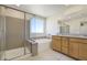 A bright bathroom showcasing a double vanity, separate shower, and a soaking tub by a window at 2343 Teatro Ave, Henderson, NV 89044