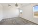 An airy bedroom featuring soft carpet and a modern ceiling fan, filled with natural light from two windows at 2343 Teatro Ave, Henderson, NV 89044