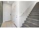 Bright entryway featuring tile floors, a white door, and a carpeted staircase with a white railing at 2343 Teatro Ave, Henderson, NV 89044