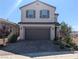 Two-story home featuring a paver driveway, a two-car garage, manicured landscaping, and mountain views at 2343 Teatro Ave, Henderson, NV 89044