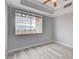 Bedroom with gray walls, wood flooring, tray ceiling, and large windows with outside views at 27 E Agate Ave # 505, Las Vegas, NV 89123