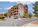 Contemporary condo building with private garages and red accents is surrounded by palm trees and lush greenery at 27 E Agate Ave # 505, Las Vegas, NV 89123