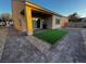 A covered patio with artificial turf and brick paver landscaping at 2704 Willow Wren Dr, North Las Vegas, NV 89084