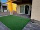 A beautiful covered patio with synthetic grass and brick pavers at 2704 Willow Wren Dr, North Las Vegas, NV 89084