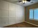Bedroom featuring paneled accent wall, wood floors and a window with plantation shutters at 2704 Willow Wren Dr, North Las Vegas, NV 89084