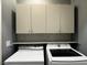 Clean laundry room featuring overhead cabinets, shelf, mosaic backsplash and washer/dryer at 2704 Willow Wren Dr, North Las Vegas, NV 89084