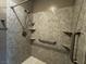 Shower with gray stone surround features a handheld shower head, and a safety bar at 2704 Willow Wren Dr, North Las Vegas, NV 89084