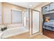 Bathroom featuring a tub, walk-in shower, a window, and decor at 2789 Trotwood Ln, Las Vegas, NV 89108