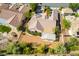 Aerial view of a well-maintained home with mature trees, desert landscaping, and a covered patio in quiet community at 3029 Brownbirds Nest Dr, Henderson, NV 89052