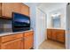 Bathroom vanity featuring wooden cabinets, next to a TV in the bedroom at 3029 Brownbirds Nest Dr, Henderson, NV 89052