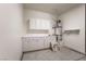 A utility room with ample cabinets, utility sink, and a water heater at 3029 Brownbirds Nest Dr, Henderson, NV 89052