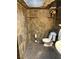 Toilet area covered with stone walls and floors and a window on the ceiling at 3167 El Cedro Cir, Las Vegas, NV 89121